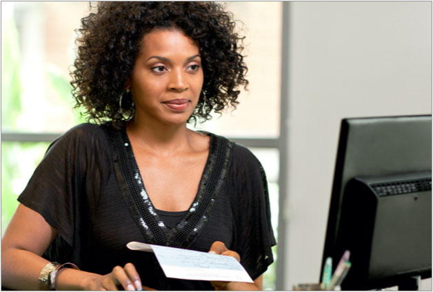 Business owner works on payroll on her computer